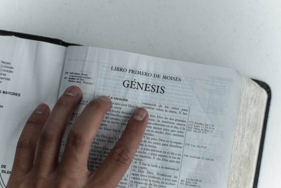 Close view of Genesis chapter in Spanish Bible, hand touching page.