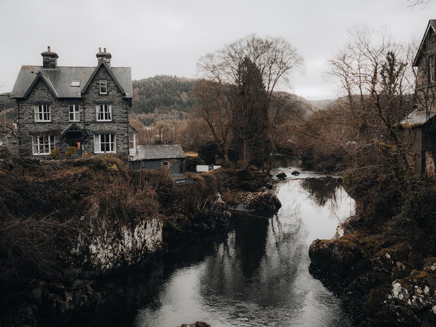 Picturesque old stone house by a tranquil river in Betws-y-Coed, Wales.