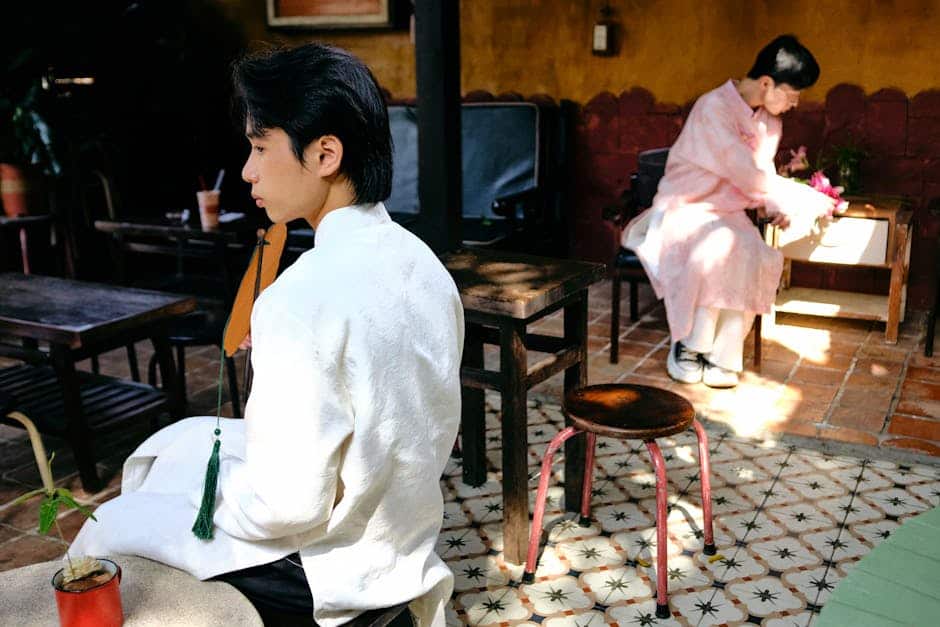 Two men wearing traditional Ao Dai in an outdoor setting in Bến Tre, Vietnam, capturing cultural elegance.