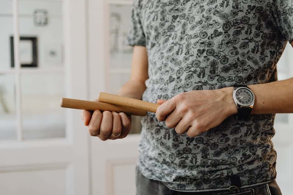 Detailed view of a person holding wooden claves, showcasing the instrument.