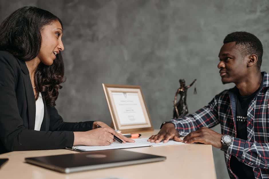 Two professionals in discussion at office desk