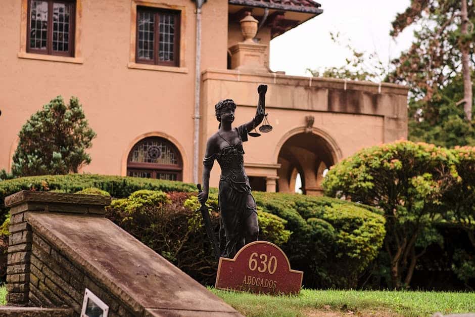 Charming mansion in Arizona City with a Lady Justice statue and manicured garden, perfect for travel and architecture themes.