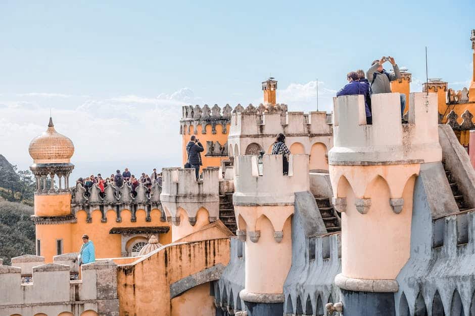 Vibrant view of tourists at the colorful Pena Palace, a UNESCO World Heritage site in Sintra, Portugal.